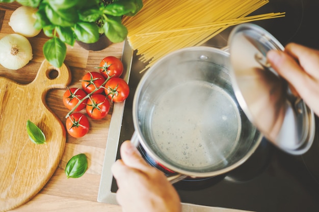 Foto uomo che cucina la pasta in acqua bollente