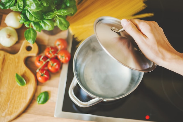 Foto uomo che cucina la pasta in acqua bollente