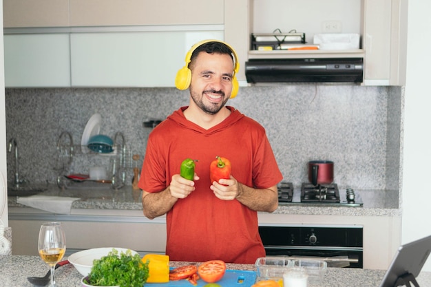 Man cooking while listening to music with headphones in the kitchen at home