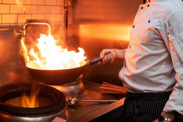 台所の火で天ぷら鍋を料理する男性