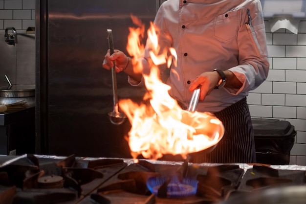 Foto un uomo cucina una friggitrice nel fuoco della cucina