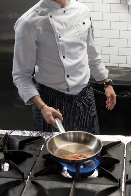 A man cooks cooking deep fryers in a kitchen fire