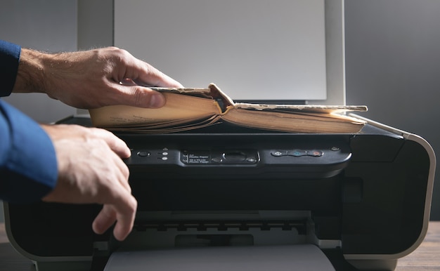 Man copying a book on a copy machine.