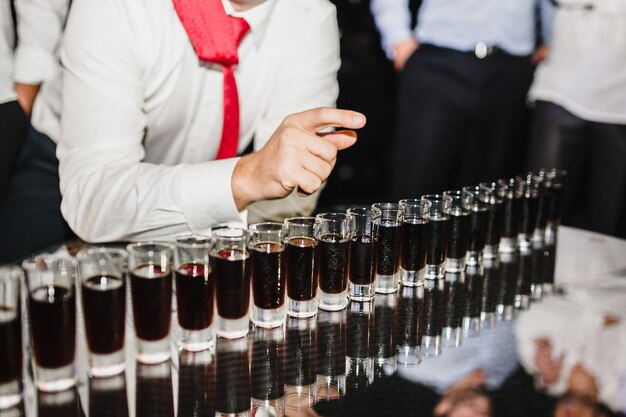 Man at a corporate party taking a shot of whiskey