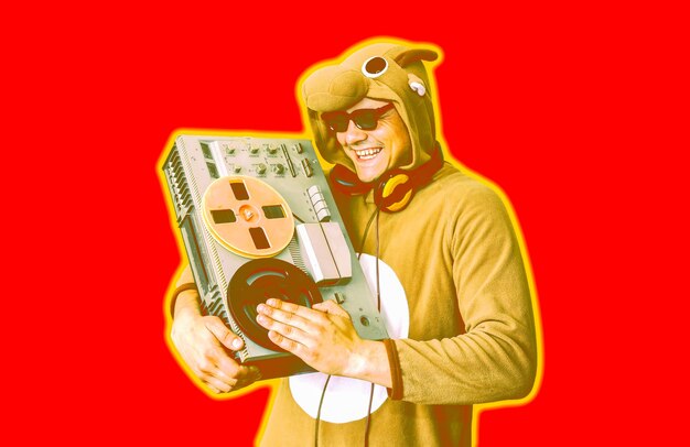 Man in cosplay costume of a cow with reel tape recorder. Guy in the animal pyjamas sleepwear. Funny photo with party ideas. Disco retro music.