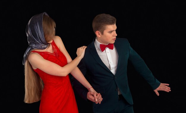 Man in costume and woman in red dress are posing