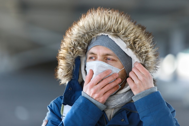 Man coughing, wearing medical protective mask