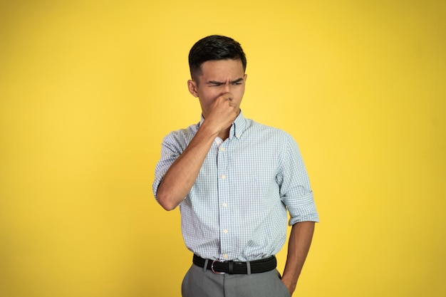 Man cover his nose and feeling disgusted by the smell