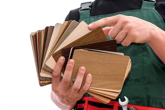 Man in coverall showing wooden sampler isolated on white