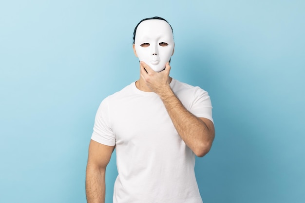 Man covering his face with white mask hiding personality conspiracy and privacy secrets