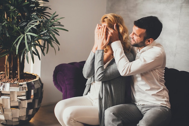 Man covering woman's eyes with his hands