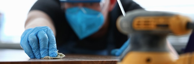 Man covering wooden tabletop with oil closeup