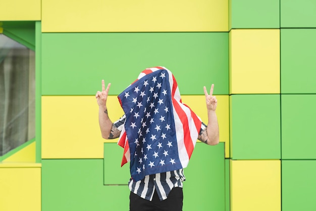 Man covers his face with usa flag