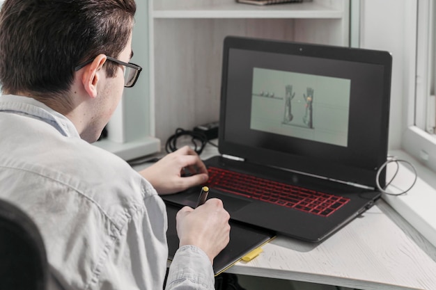 Foto l'uomo crea videogiochi, un designer crea un modello 3d sul suo laptop