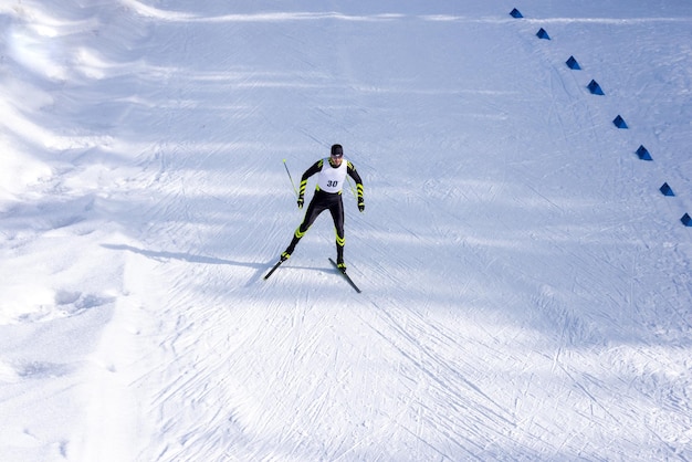 A man crosscountry skiing race on the trail Man in modern ski running clothes with number on chest