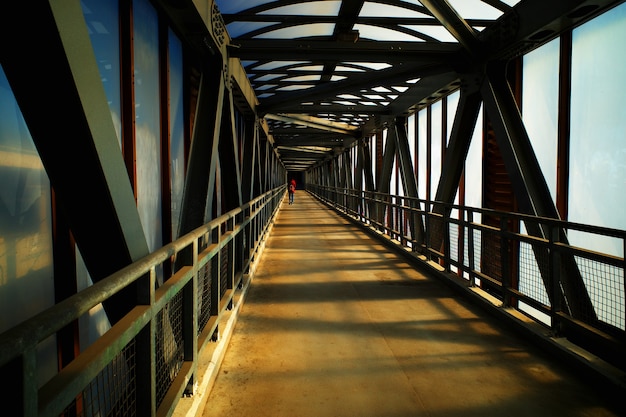 Man crossing city bridge during sunset time background