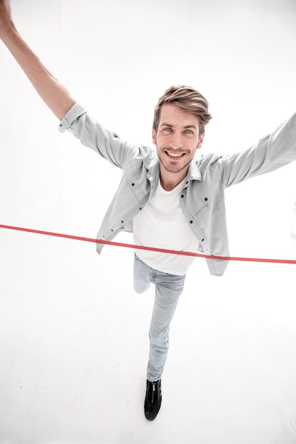 Man crossing the finish line against white background