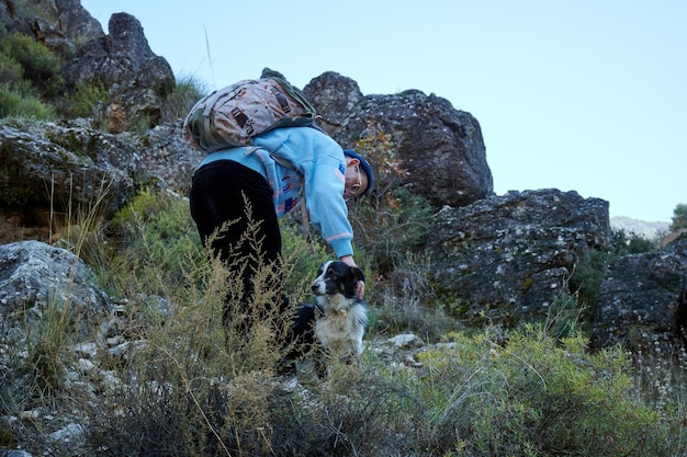 A man cuddling a dog in the mountain