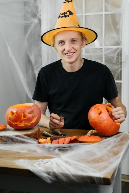 Man curving jac o lanten helloween pumpkin at home