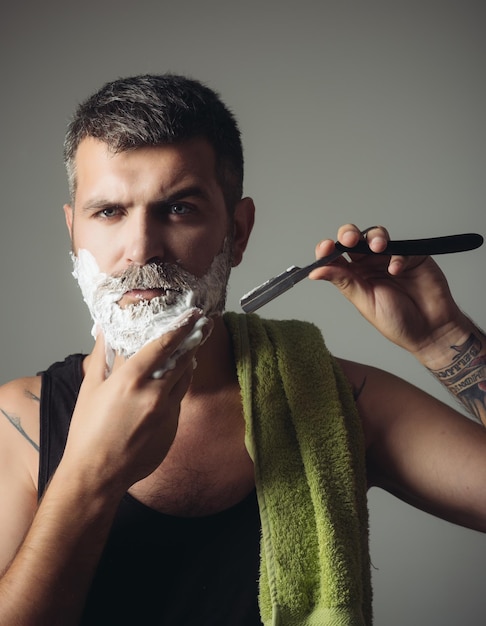 Foto uomo tagliato barba e baffi con rasoio e pennello da barba