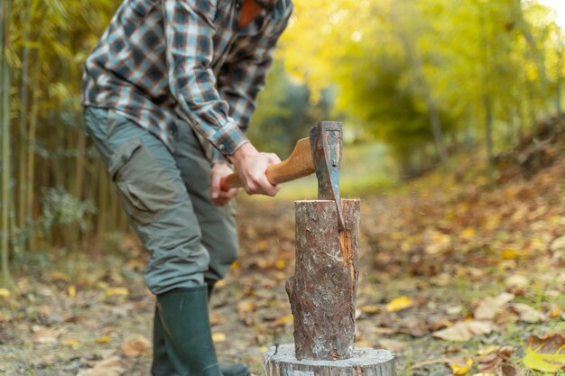 Uomo tagliato con ascia polvere e movimenti taglialegna seghe albero con motosega su segheria lumberjack