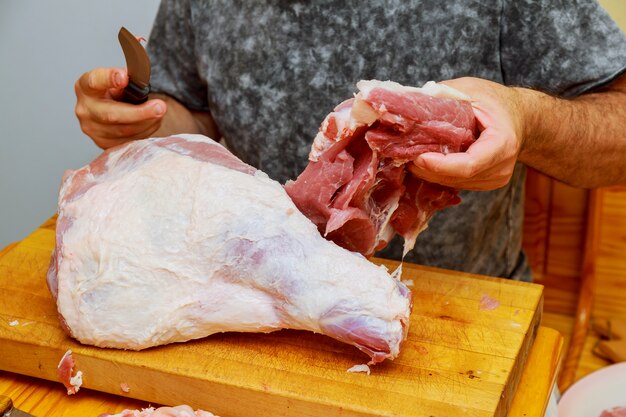 Equipaggi i tagli del pezzo di carne fresco su un tagliere di legno la cucina domestica