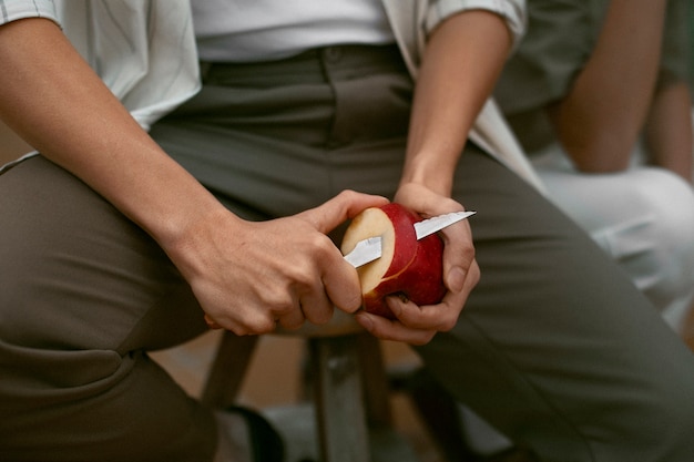 Photo man cutting apple with knife