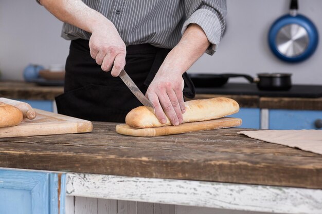 Man cutting bread on kitchen