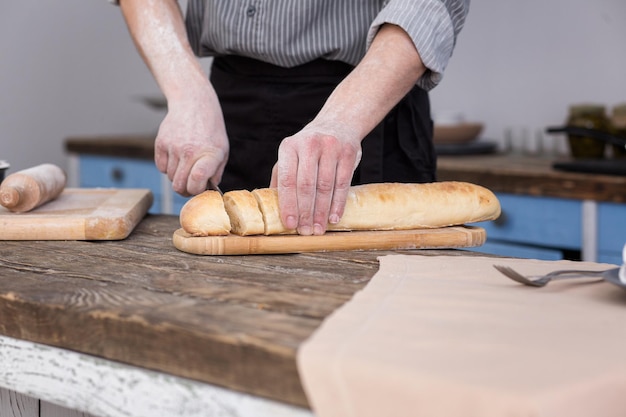 Man cutting bread on kitchen