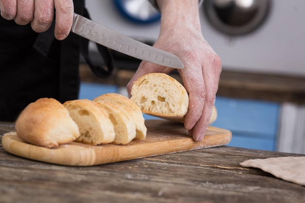 Man cutting bread on kitchen