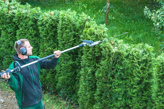 Photo man cutting bushes