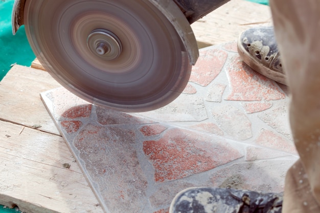 A man cutting a floor tiles