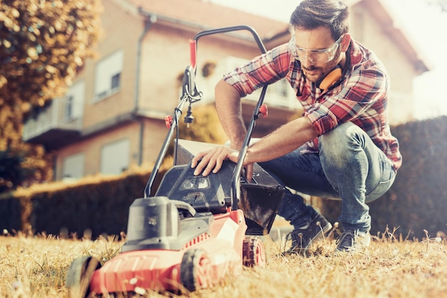 Man cutting grass in his yard