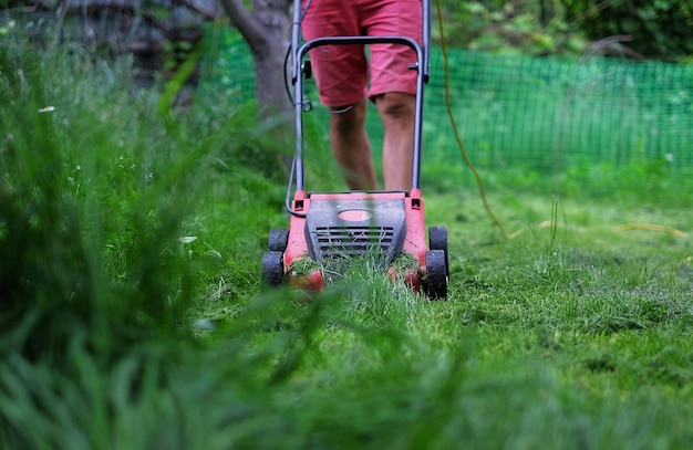 A man cutting the grass with a lawn mower