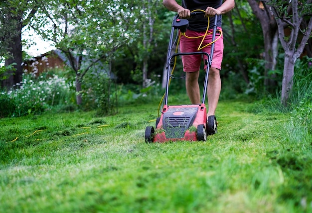 A man cutting the grass with a lawn mower