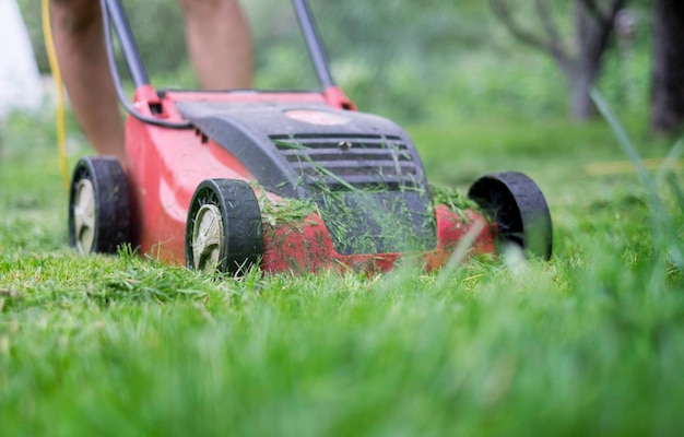 A man cutting the grass with a lawn mower