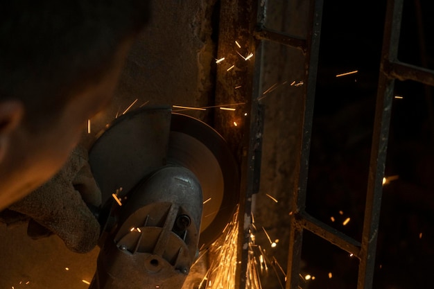 A man cutting the iron with a angle grinder