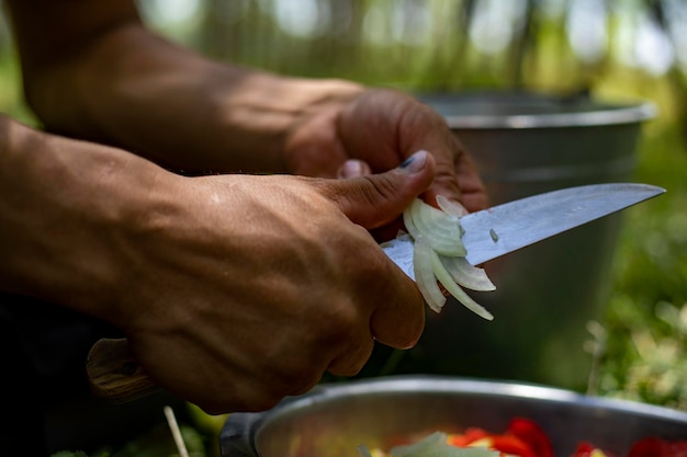 мужчина режет лук ножом без разделочной доски