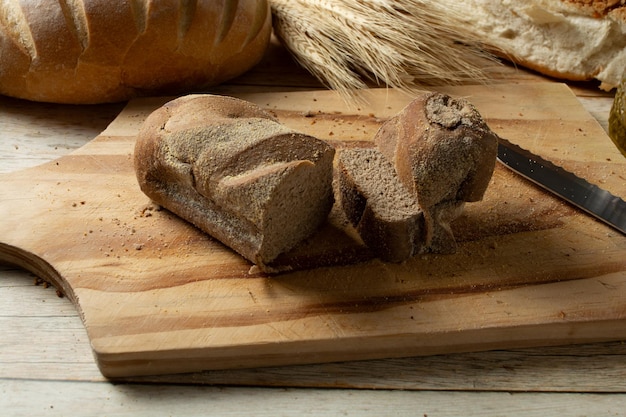 man cutting slices of dark bread or australian bread