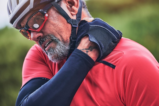 Man cyclist and neck injury in sports accident emergency or broken bone and fitness in nature Closeup of male person or athlete with sore pain ache or joint inflammation from cycling or fall