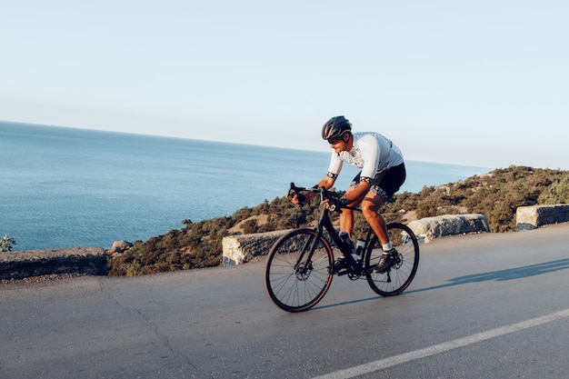 Ciclista dell'uomo che pedala su una bici da strada all'aperto