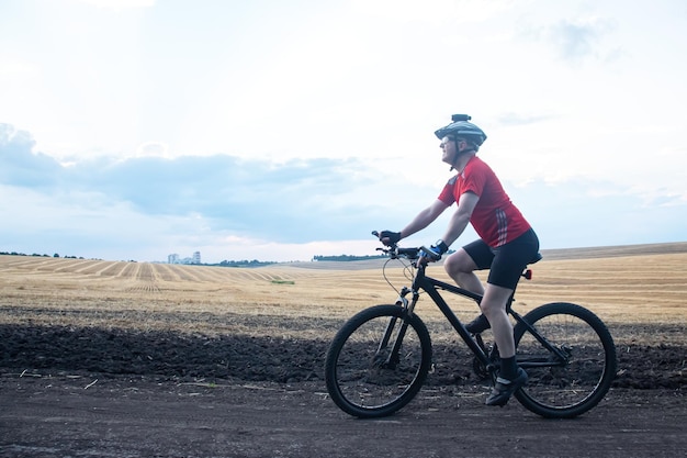 Мужчина-велосипедист едет на велосипеде по дороге в природе, занимается спортом, ездит на велосипеде и занимается здоровьем.