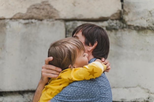 Uomo papà che ha tempo di qualità con il loro bambino figlio ragazzo di sei anni abbraccio sulle braccia padre felice che gioca insieme al bambino vita reale autentico momenti di paternità di tutti i giorni amore paterno cura affetto