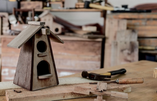 Man daily lifestyle at home. Woodworking and DIY vintage wooden bird house for garden decoration. Carpenter and craftsman workshop.