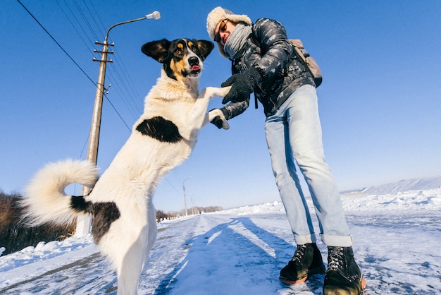 Man dansen met dakloze hond in de winter