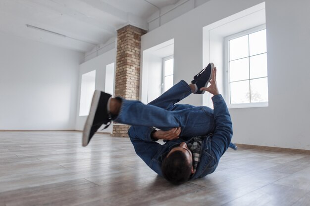 Man danser in mode denim kleding dansen in de studio