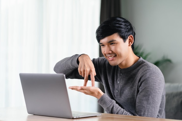 Photo man deaf disabled using laptop computer for online video conference call sign language