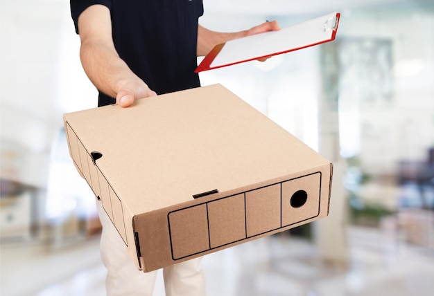 Man delivering package, holding clipboard for signature