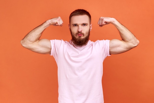 Man demonstrating power in his hands showing biceps feeling energy to win success