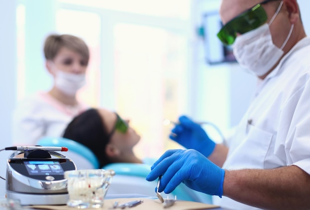 Man dentist working at his patients teeth